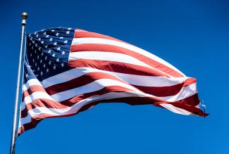 us a flag under blue sky during daytime by chris robert courtesy of Unsplash.