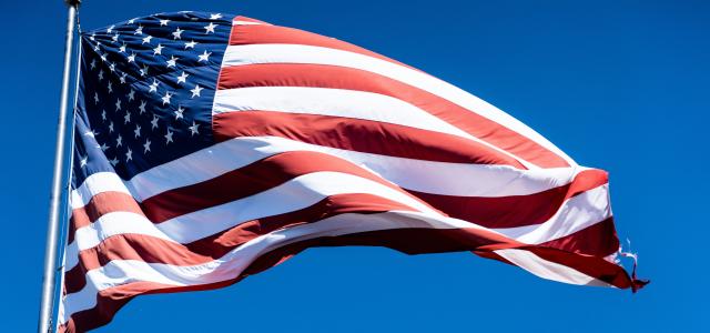 us a flag under blue sky during daytime by chris robert courtesy of Unsplash.