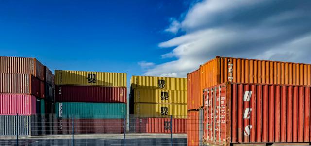 a truck is parked in front of a bunch of shipping containers by Bernd 📷 Dittrich courtesy of Unsplash.
